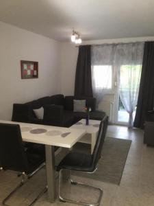 ein Wohnzimmer mit einem Tisch und einem schwarzen Sofa in der Unterkunft Apartments with a parking space Stubicke Toplice, Zagorje - 22028 in Stubicke Toplice