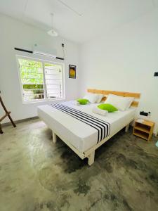 a large bed in a white room with a window at Mahagedara Dickwella in Dickwella