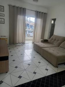 uma sala de estar com um sofá e piso em azulejo em Locação Casa Residencial Guarujá - Alta Temporada no Guarujá