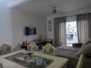 uma sala de estar com um sofá e uma mesa em Locação Casa Residencial Guarujá - Alta Temporada no Guarujá