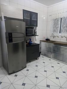 a kitchen with a stainless steel refrigerator in it at Locação Casa Residencial Guarujá - Alta Temporada in Guarujá