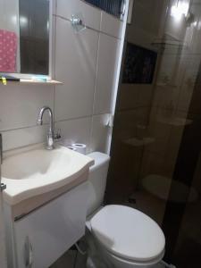 uma casa de banho com um WC, um lavatório e um chuveiro em Locação Casa Residencial Guarujá - Alta Temporada no Guarujá