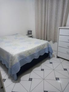 a bedroom with a bed and a white tiled floor at Locação Casa Residencial Guarujá - Alta Temporada in Guarujá