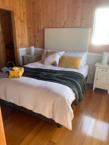 a large bed in a room with wooden walls at Hazelcreek Cottages in Exeter