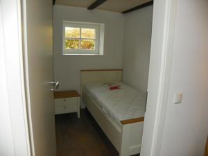 Habitación pequeña con cama y ventana en Ferienwohnung Göttsche-Hof, en Hennstedt