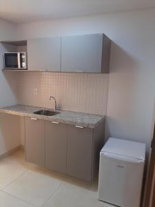 a kitchen with a sink and a counter top at Guest Manaíra Apart Hotel in João Pessoa