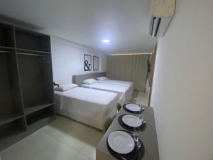 um quarto de hotel com duas camas e um lavatório em Guest Manaíra Apart Hotel em João Pessoa