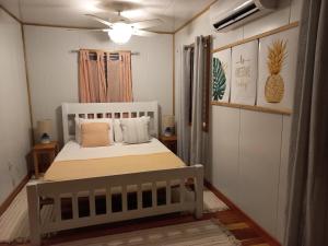 Un dormitorio con una cama blanca con almohadas. en Mariposa Jungle Lodge en San Ignacio