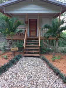 une maison avec un escalier menant à une terrasse couverte dans l'établissement Mariposa Jungle Lodge, à San Ignacio