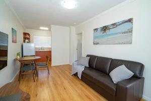 a living room with a couch and a table at 24 Burswood Comfort Short Walk To Crown & Optus! - Superhog verification Required in Perth