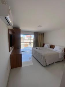 a bedroom with a bed and a flat screen tv at Serra Plaza Premium in Serrinha