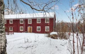un granero rojo con nieve encima en Nice Home In Klubbcken With Sauna, 