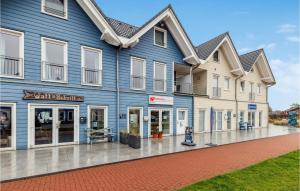 a large blue building with windows on a street at Nice Home In Dagebll With Kitchen in Dagebüll