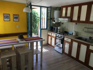 uma cozinha com armários de madeira e um forno com placa de fogão em Casa Santa Barbara em Godoy Cruz