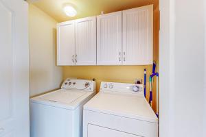 a laundry room with white cabinets and a washer and dryer at Captiva Bay 202 in Ocean City
