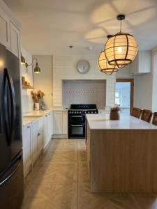 a kitchen with white cabinets and a black stove at Fern Lodge by Birch Stays in Rhosneigr
