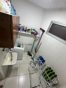 uma casa de banho com ferramentas de limpeza num piso de azulejo em Praia em Lauro de Freitas