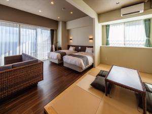 本部町にあるSunset Resort Canphouのベッド2台とソファが備わるホテルルームです。