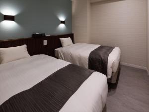 本部町にあるSunset Resort Canphouのベッド2台と照明2つが備わるホテルルームです。