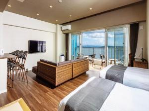 本部町にあるSunset Resort Canphouのベッド2台とバルコニーが備わるホテルルームです。