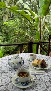 stół z dwoma filiżankami herbaty i ciastem na nim w obiekcie Dosemo Cabana w mieście Induruwa