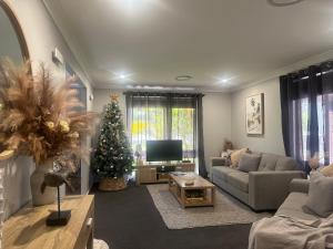 a living room with a christmas tree and a television at 'Anchor Management' Recently Renovated 3BR / 2BTH in Nelson Bay
