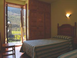 a bedroom with a bed and a balcony with a view at Casa Rural Hortal in Barruera