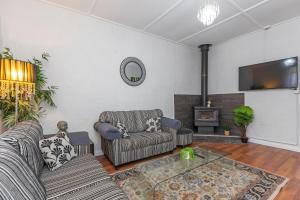 a living room with two couches and a fireplace at Stylish Lake Albert Cottage, Wagga Wagga in Wagga Wagga