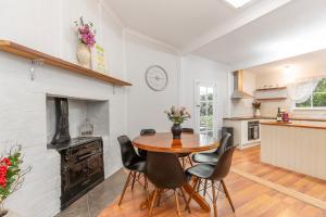 a kitchen and dining room with a wooden table and chairs at Stylish Lake Albert Cottage, Wagga Wagga in Wagga Wagga