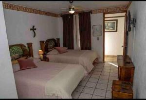 a bedroom with two beds and a cross on the wall at Las Linas in Tequisquiapan +15 photos