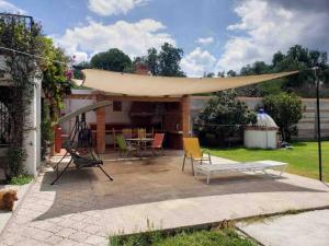 a patio with a table and chairs and a tent at Las Linas in Tequisquiapan