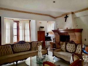 a living room with a couch and a fireplace at Las Linas in Tequisquiapan