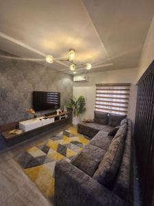a living room with a couch and a tv at Luxury 4 Bdr Home in the city in Abuja