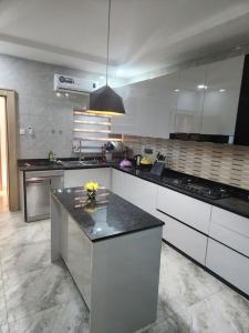 a kitchen with white cabinets and a black counter top at Luxury 4 Bdr Home in the city in Abuja