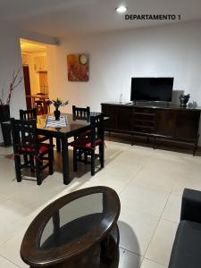 a living room with a table and chairs and a television at Sabattini Apart in Villa María