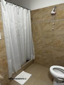 a bathroom with a shower curtain and a toilet at Sabattini Apart in Villa María +38 photos