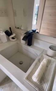 ein weißes Badezimmer mit einem Waschbecken und einem Spiegel in der Unterkunft ¡Un Espacio Mágico en El Valle! in Santa Bárbara de Samaná