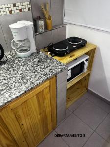 cocina con encimera y microondas en Sabattini Apart en Villa María