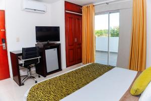 a bedroom with a bed and a desk and a television at Hotel Luxor Cúcuta in Cúcuta
