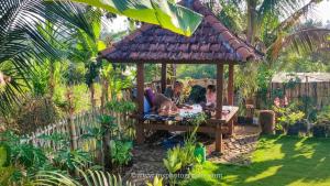 un grupo de personas en un cenador en un jardín en Kurni's Cabin, en Sapit