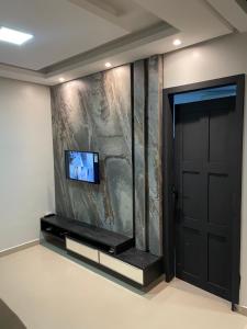 um quarto com uma porta e uma televisão na parede em Apto Moderno - Centro em Macapá