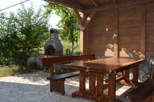 a picnic table and a bench in front of a cabin at Apartments Buljan in Baška