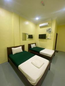 a hospital room with two beds and a fan at Fadlim Homestay in Padang Serai