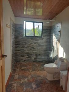 La salle de bains est pourvue de toilettes et d'une fenêtre. dans l'établissement Cabaña Niraj, à Cartago