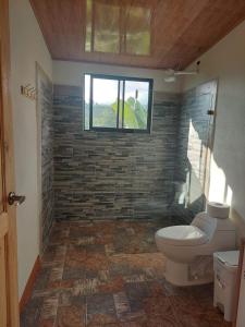 a bathroom with a toilet and a window at Cabaña Niraj in Cartago +5 photos