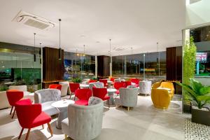 un ristorante con tavoli e sedie rossi e bianchi di Grand Citiview Da Nang Hotel a Da Nang