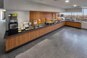 a restaurant with a counter with food on it at City Express by Marriott Monterrey Santa Catarina in Monterrey