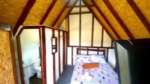 Dormitorio pequeño con cama en el ático en Cabañas Villa Loe, en Jardín