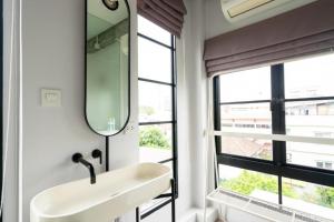 bagno con lavandino e specchio di Bedspread Hostel a Bangkok