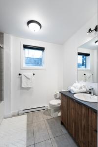 La salle de bains blanche est pourvue d'un lavabo et de toilettes. dans l'établissement Denis, à Québec